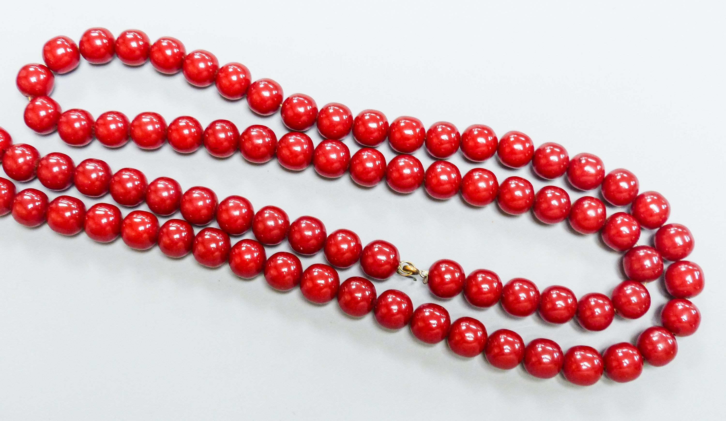 A group of loose simulated cherry amber beads and one other similar necklace, gross weight 254 grams.